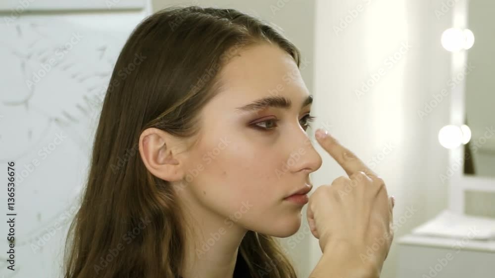 Professional female make-up artist applying eyeshadow on the eyelid on the girl's face. HD Professional female make-up artist applying eyeshadow on the eyelid on the girl's face. HD