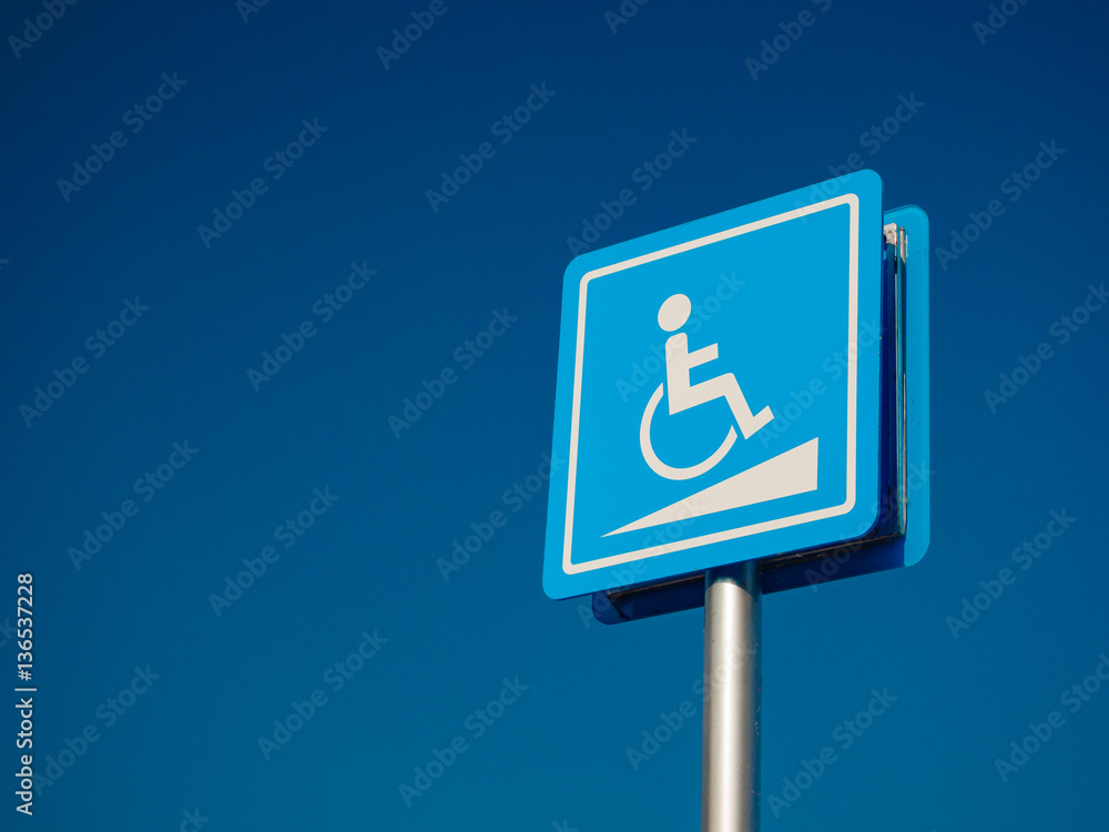 Disabled parking space and wheelchair way sign and symbols on a pole warning motorists Disabled parking space and wheelchair way sign and symbols on a pole warning motorists
