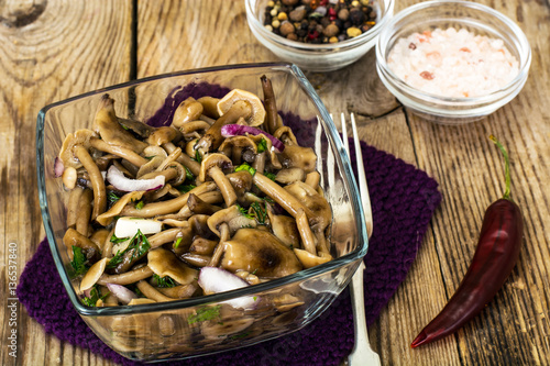 Marinated mushrooms and onions in a glass salad bowl
