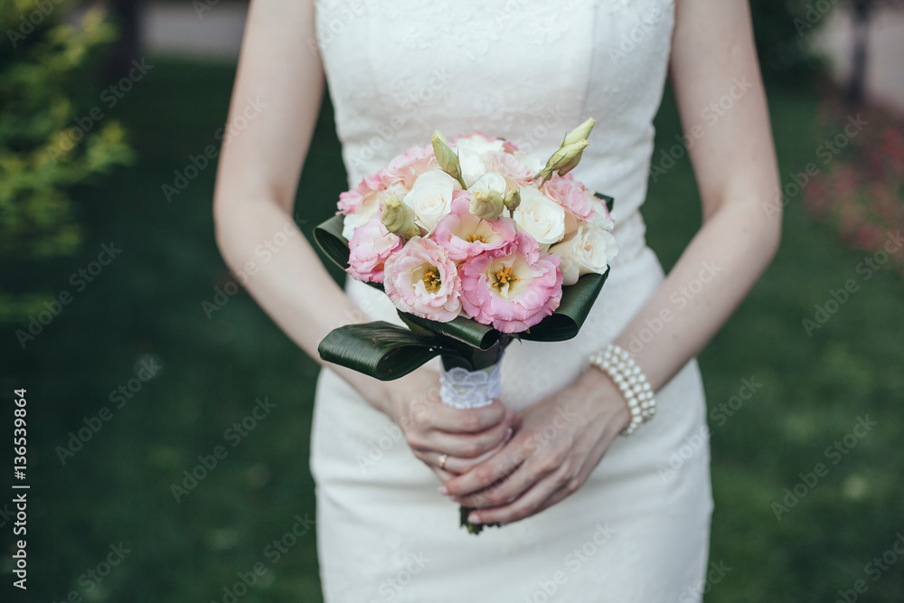 Wedding. The bride in a dress standing in a green garden and hol Wedding. The bride in a dress standing in a green garden and hol