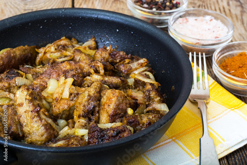 Fried beef liver with onions, curry and spices