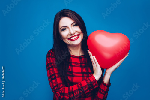 Schilderij op canvas Beautiful girl holding a heart shape symbol in hands.