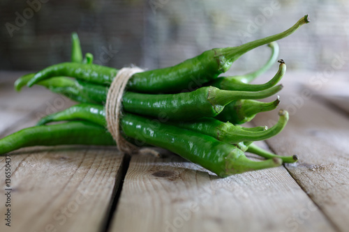 green peppers in a bunch on the wooden background