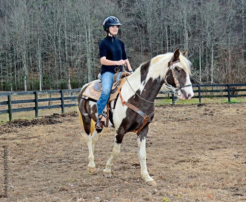 Teenage Girl Riding Horse in a Pasture