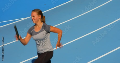 Female Athlete Running in Relay Race with Baton in hand.