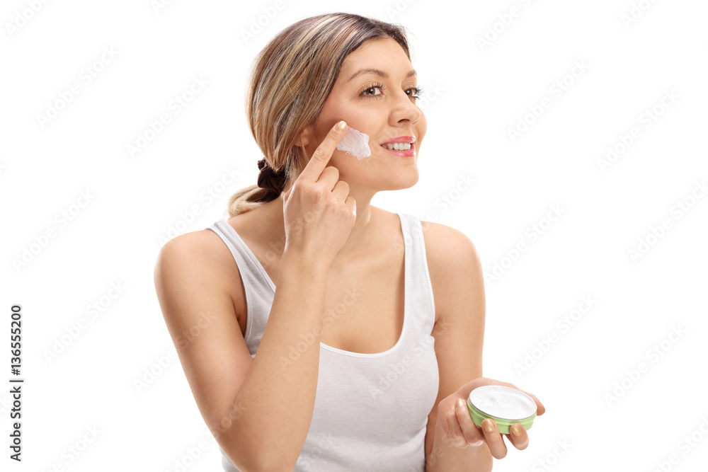 Pretty woman applying skin cream on her face Pretty woman applying skin cream on her face