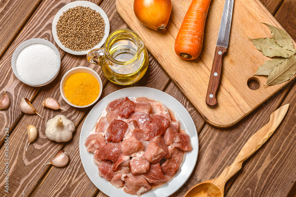 Cooking ingredients: sliced raw meat, oil, spices, garlic, carrot, onion, Cooking ingredients: sliced raw meat, oil, spices, garlic, carrot, onion,