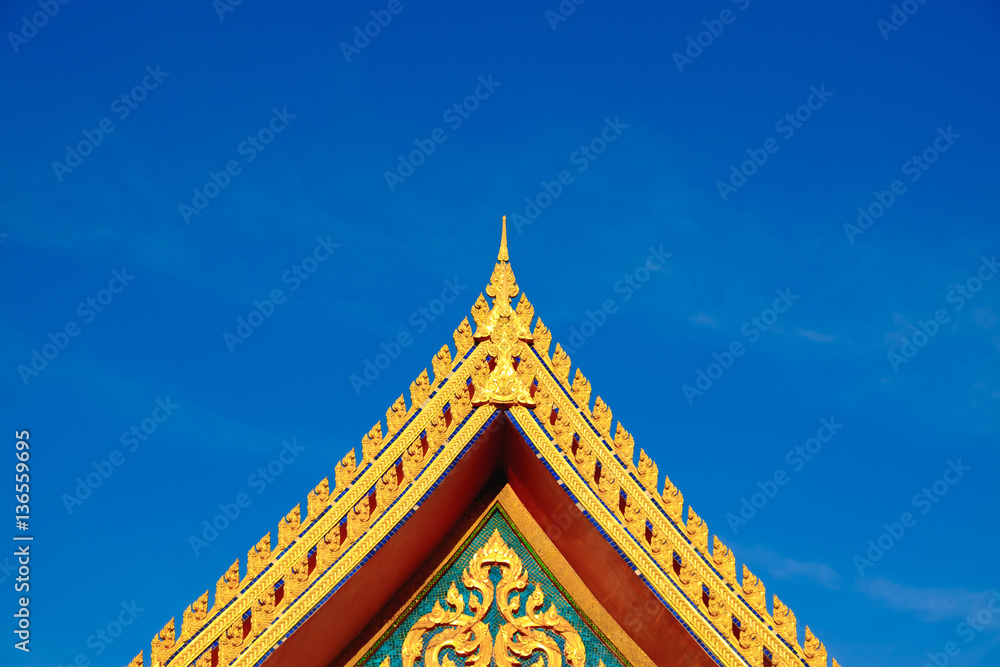 Gold color roof of buddhist temple with blue sky background.
