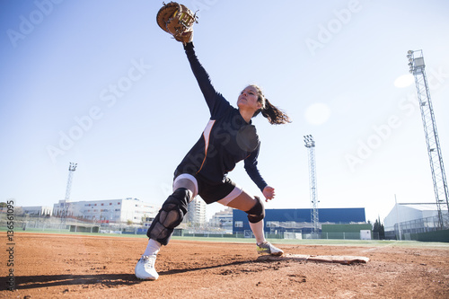 Female baseman catching the ball during a baseball game photo