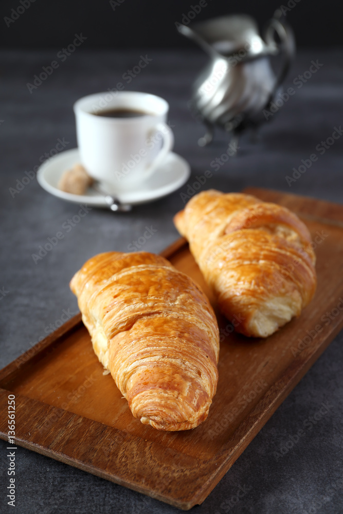 Two fresh croissants and cup of coffee
