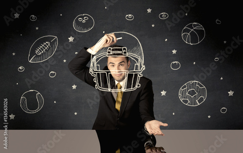 Businessman drawing helmet and sport balls