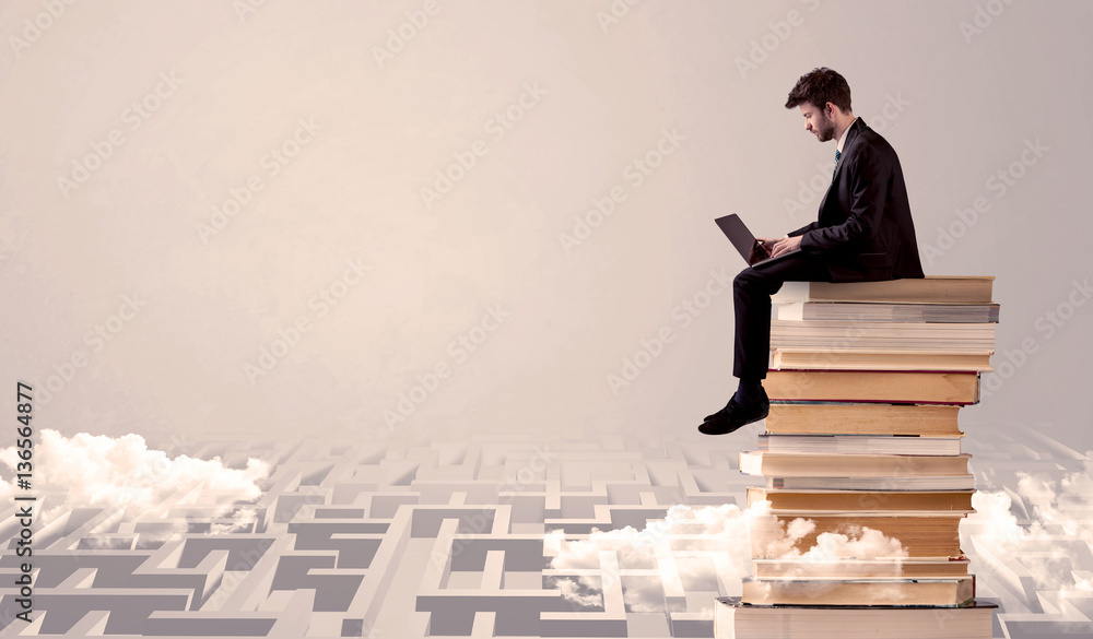 Man with tablet sitting on books Man with tablet sitting on books
