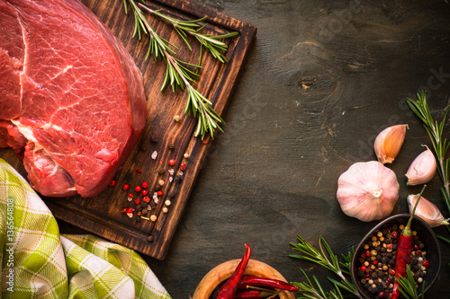 A large piece of beef chop on a cutting board. raw meat.