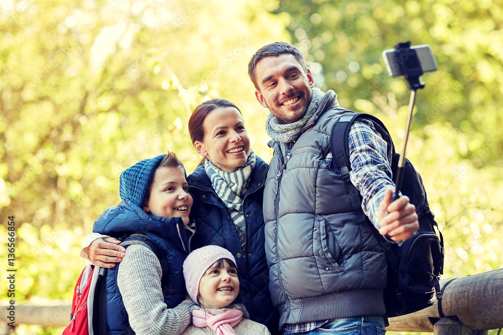 happy family with smartphone selfie stick in woods happy family with smartphone selfie stick in woods