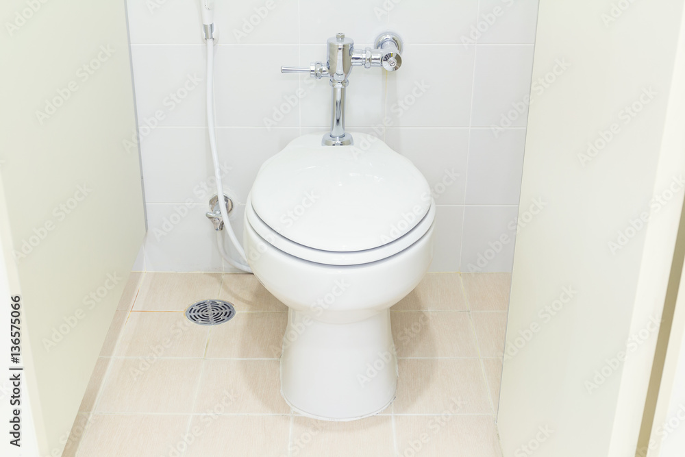 White water closet and tile floor in toilet room. White water closet and tile floor in toilet room.