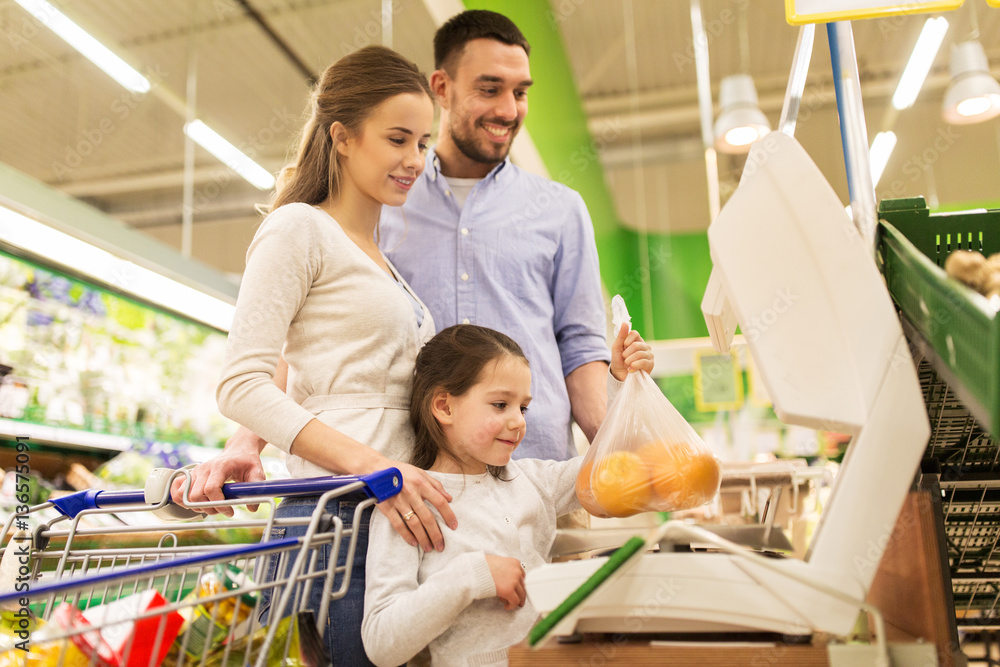 Obraz premium family weighing oranges on scale at grocery store