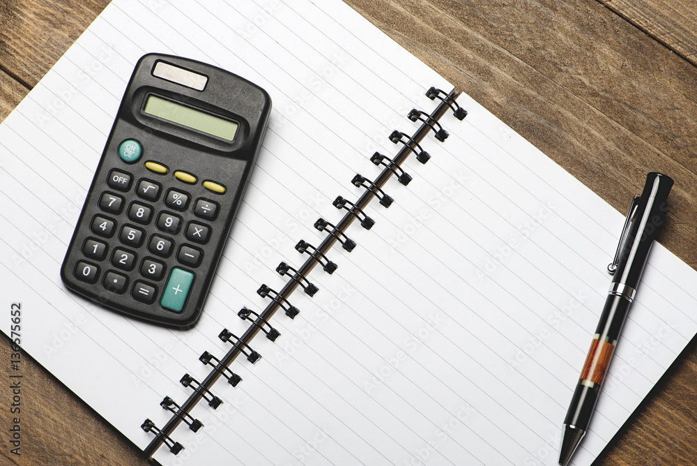 Office still-life with pen and calculator on brown wooden table. Office still-life with pen and calculator on brown wooden table.