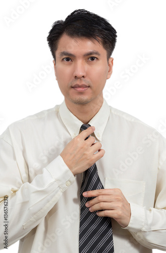 portrait of asian young handsome business man touching necktie, isolated on white photo