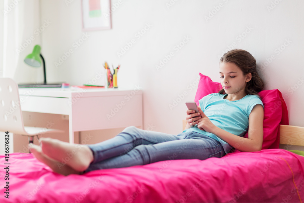 smiling girl texting on smartphone at home smiling girl texting on smartphone at home