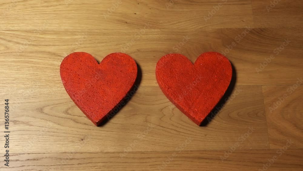 Beautiful female hands putting two red heart shapes on wooden table. Love, Valentine's day, togetherness, family, date concepts. 4K video, top view Beautiful female hands putting two red heart shapes on wooden table. Love, Valentine's day, togetherness, family, date concepts. 4K video, top view