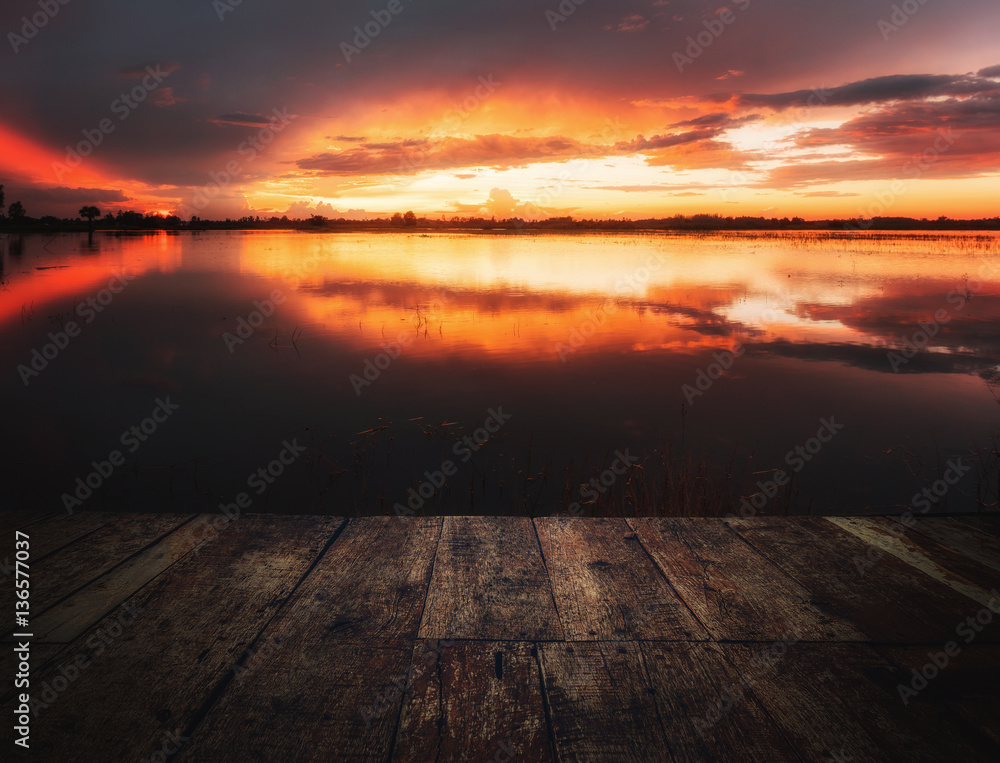 image of wooden floor in front of lake at sunset time,can be used for display or montage your products.
