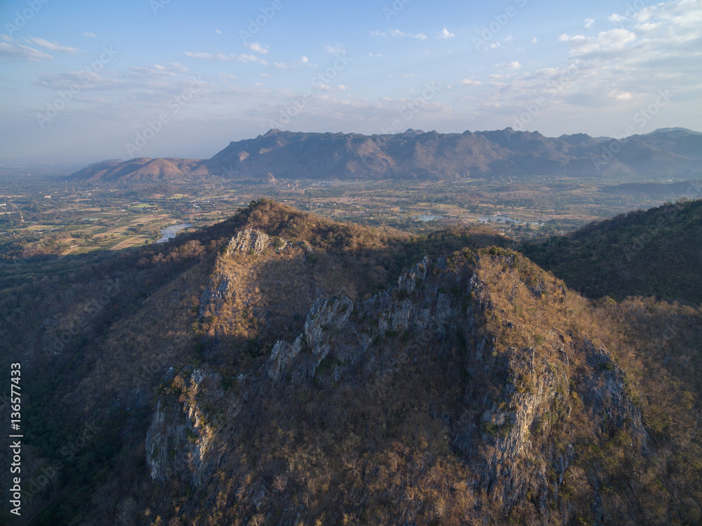 Rocky cliff and mountain range with highland and houses background