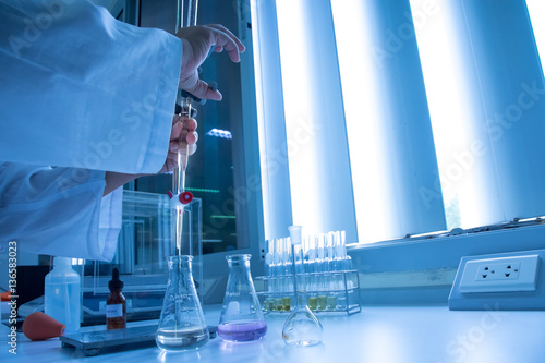 Scientist hand setting up buret or burette