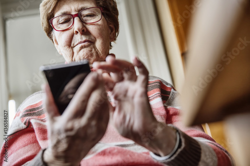 Seniorin mit einem Smartphone photo