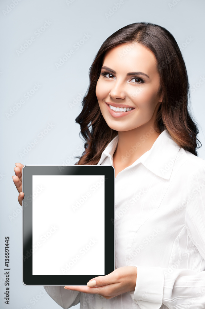Businesswoman showing blank tablet pc, on grey Businesswoman showing blank tablet pc, on grey