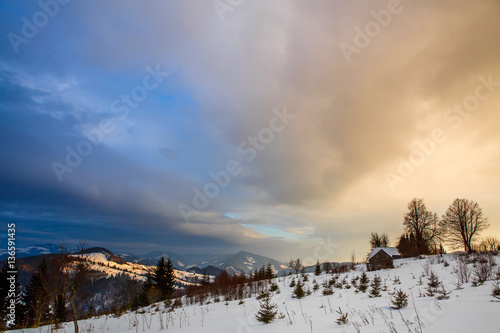 Winter mountain landscape at sunset with dramatic clouds Ukrainian Carpathians