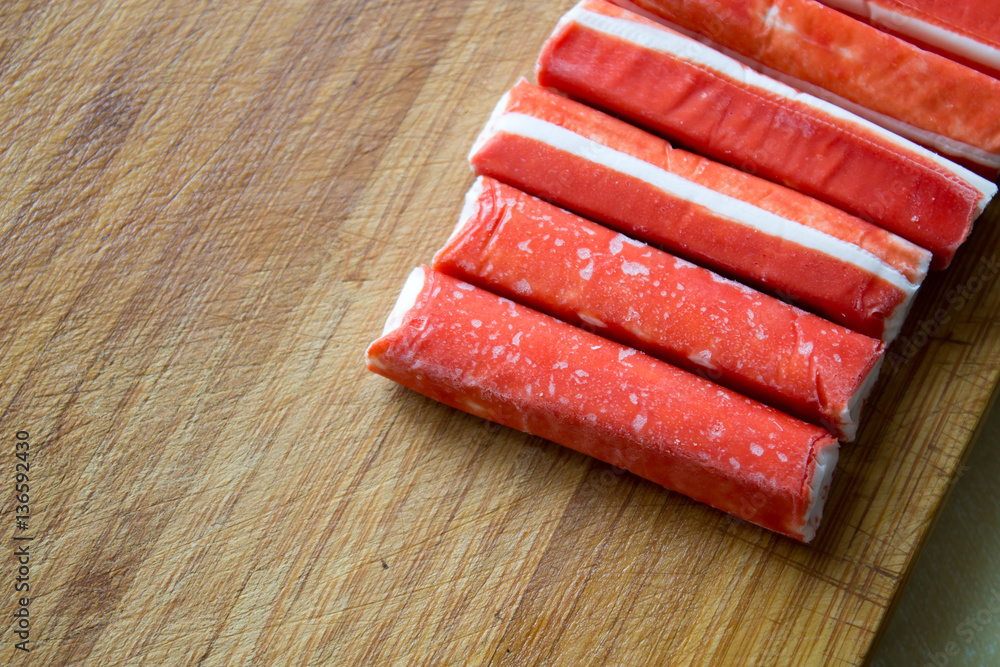 frozen crab sticks on a wooden board frozen crab sticks on a wooden board
