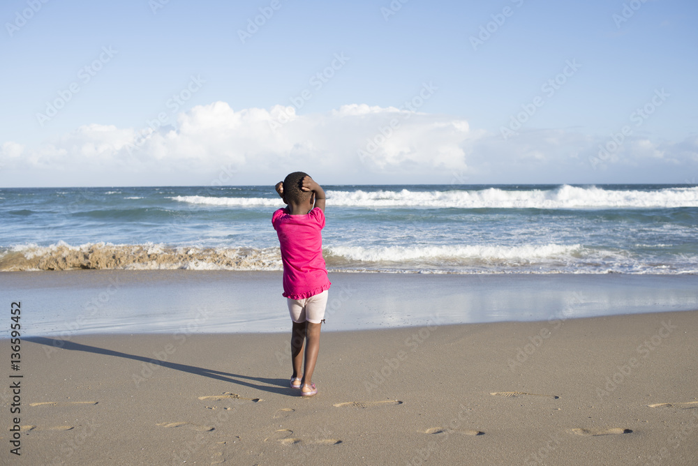 Little girl alone on beach.