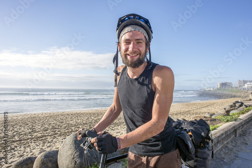 Touring Cyclist with Bicycle by Beach