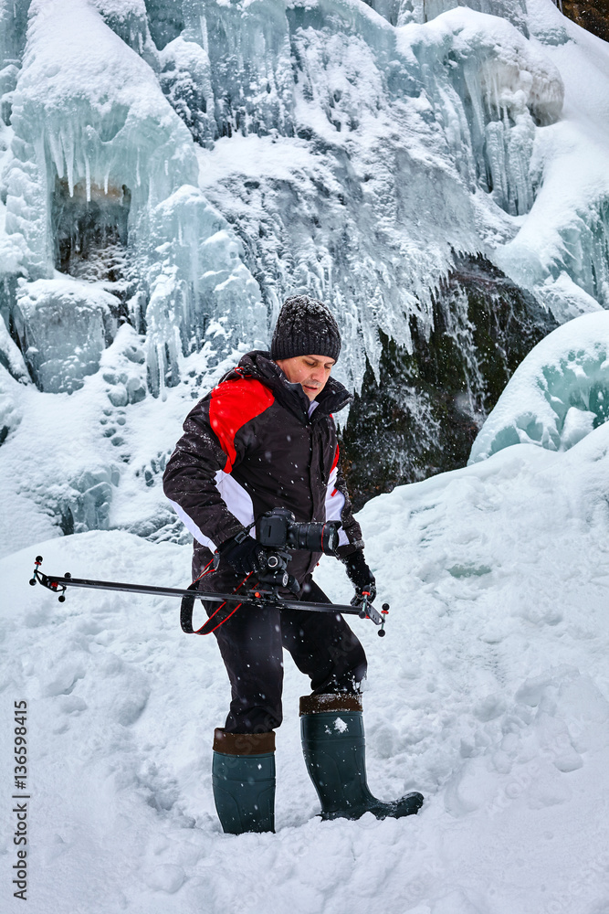 Landscape photographer at frozen waterfall Landscape photographer at frozen waterfall