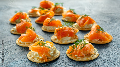 Smoked Salmon and soft chees canapes appetizers with chives on stone table