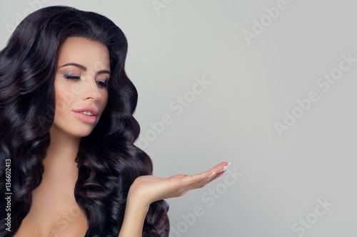 Perfect Model Woman with Long Curly Hairstyle Showing at her Han