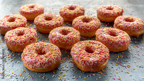 Iced doughnut rings with rainbow sparkl strands.