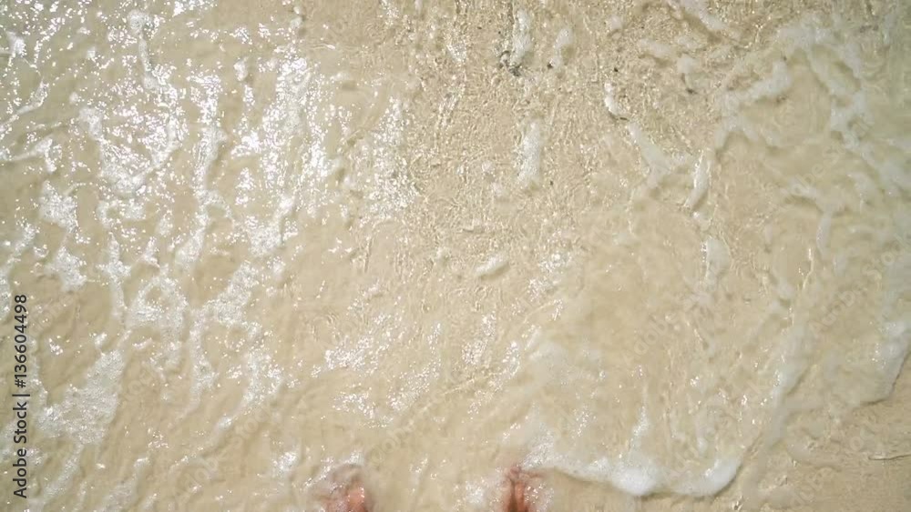 a man standing on the beach. white sand and clear water. first-person view a man standing on the beach. white sand and clear water. first-person view