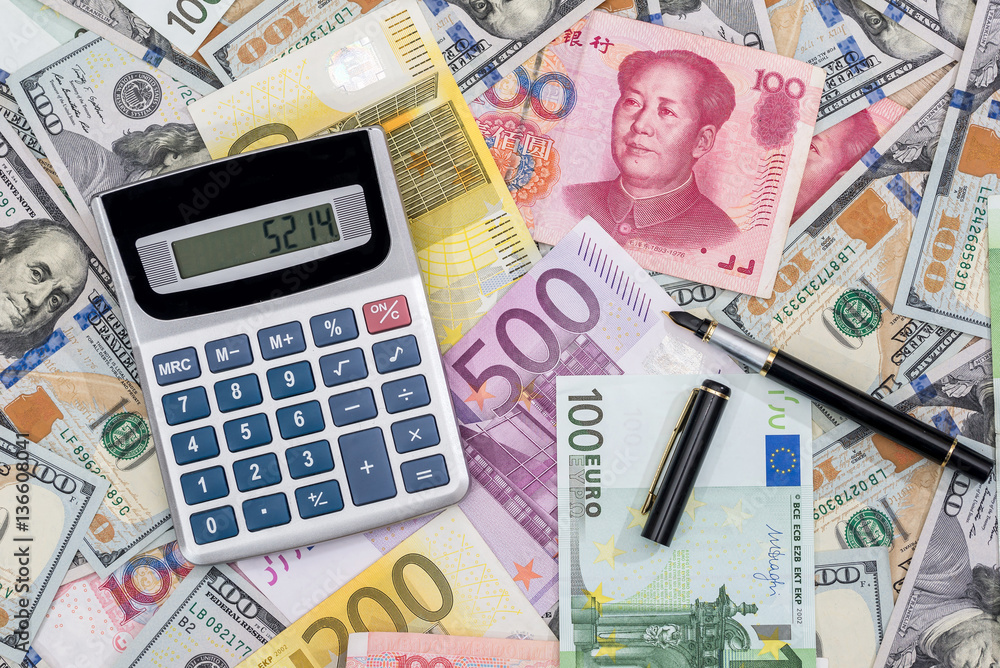 Calculator with euros, dolalr and yuan with pen on desk. Calculator with euros, dolalr and yuan with pen on desk.