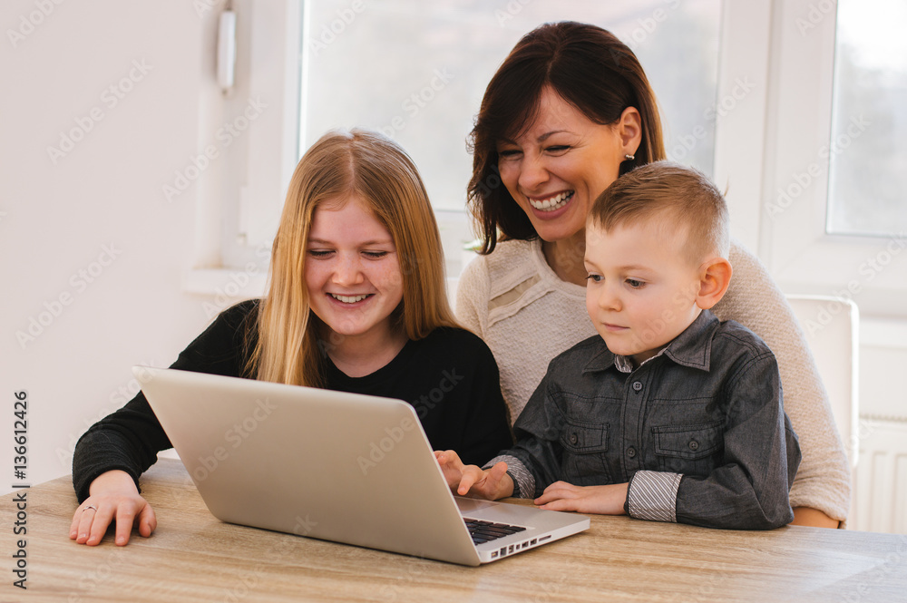 Mother with kids playing on laptop computer Mother with kids playing on laptop computer