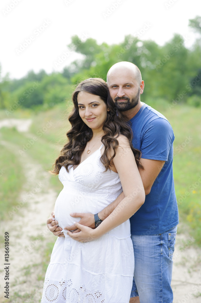 Pregnant woman and her husband in the park Pregnant woman and her husband in the park