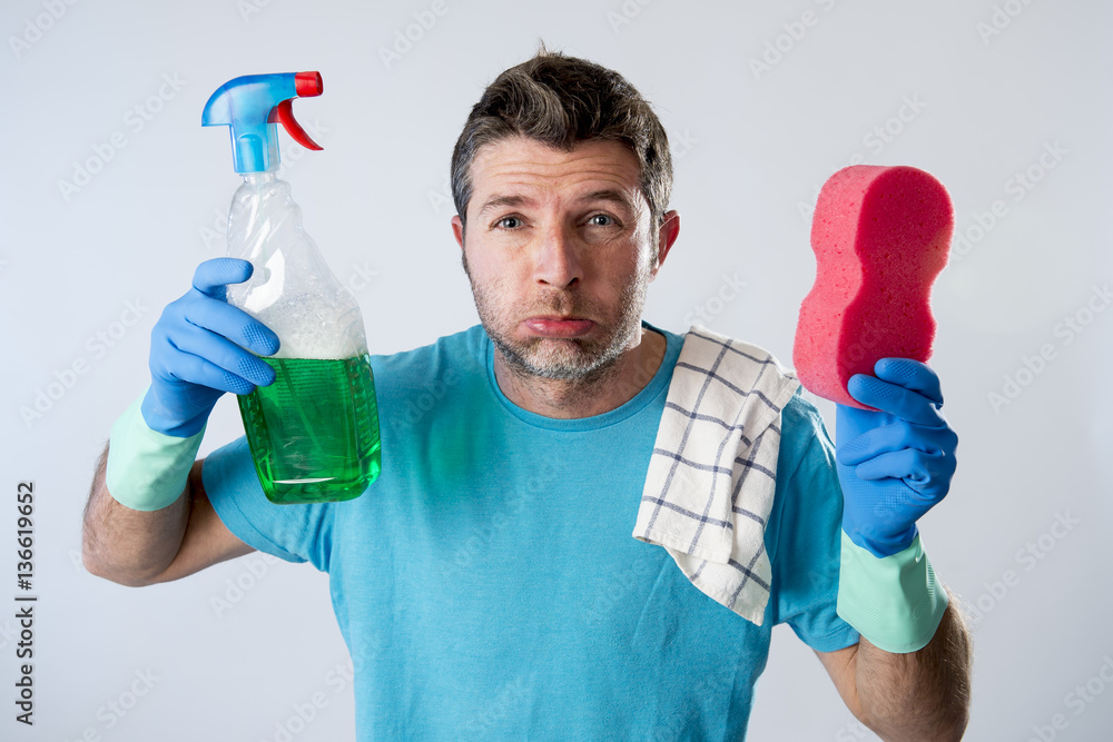 domestic service man or tired husband angry and stressed house cleaning with spray bottle and sponge domestic service man or tired husband angry and stressed house cleaning with spray bottle and sponge