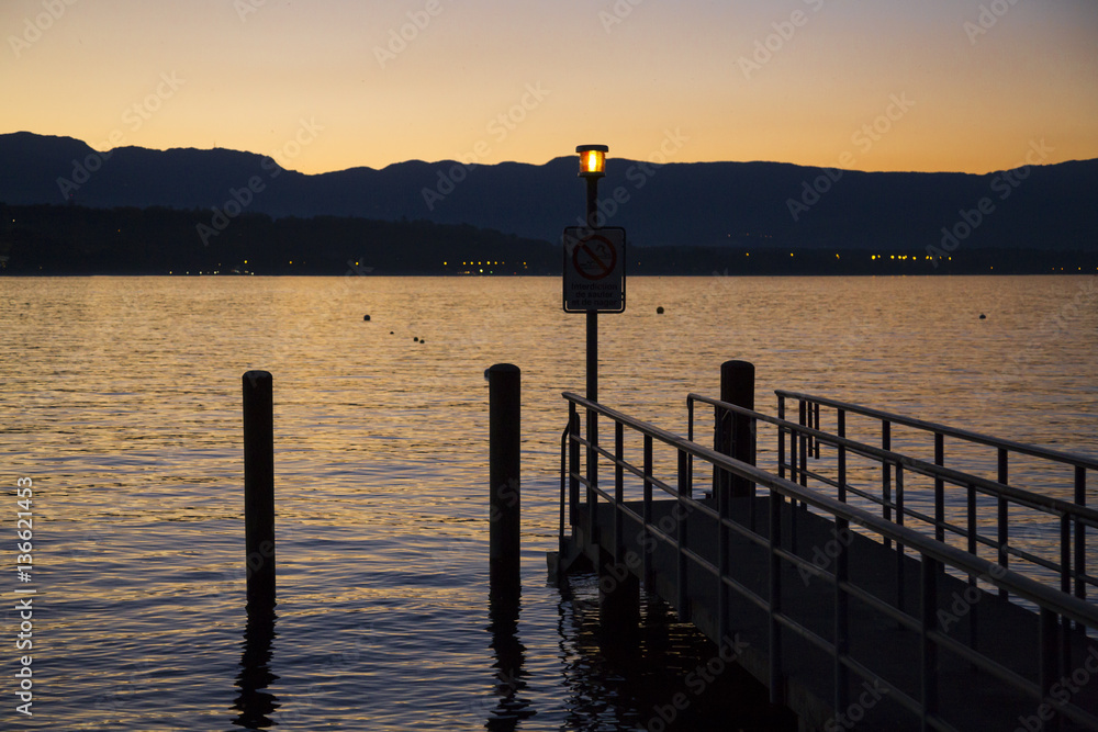 Orange sunset and jetty on Lake Geneva