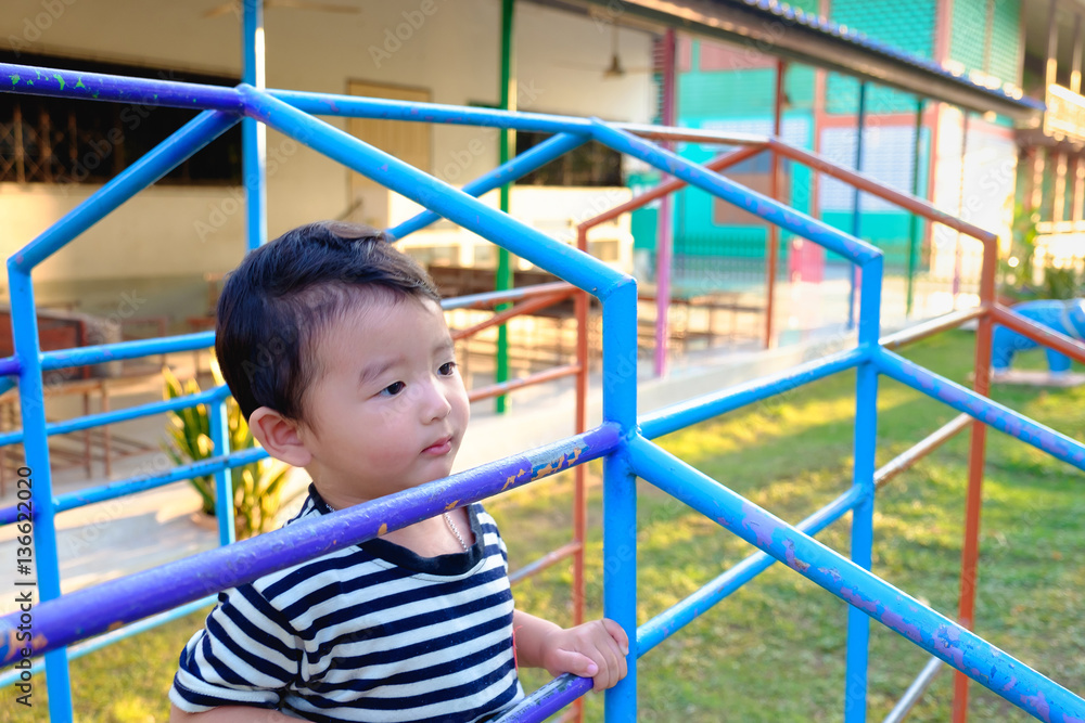 Asian boy hang the metal bar at outdoor playground. Asian boy hang the metal bar at outdoor playground.