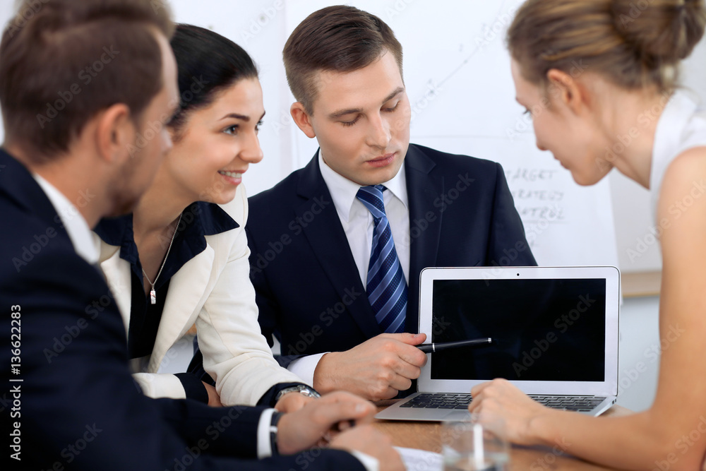 Business people at meeting in the office. Focus on woman pointing into laptop Business people at meeting in the office. Focus on woman pointing into laptop