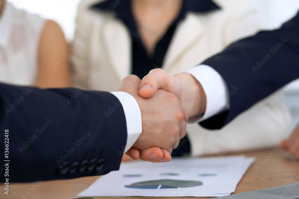 Close up of business people shaking hands at meeting or negotiation in the office. Partners are satisfied because signing contract Close up of business people shaking hands at meeting or negotiation in the office. Partners are satisfied because signing contract