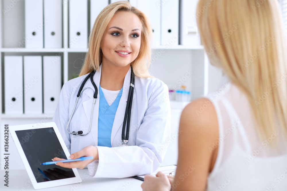 Doctor and  patient  discussing something while phisician pointing into laptop computer. Medicine and health care concept