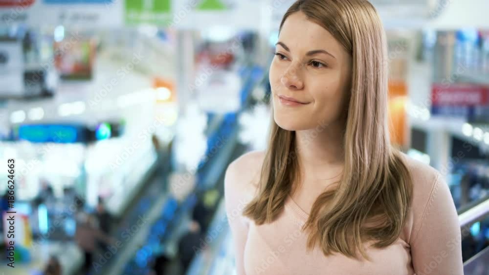 Beautiful young attractive woman waiting for a friend in a mall. Shopping consumerism concept. Beautiful young attractive woman waiting for a friend in a mall. Shopping consumerism concept.