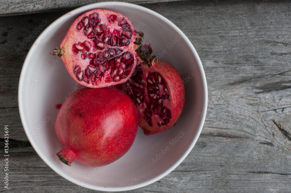 pomegranet in the bow on the wooden table pomegranet in the bow on the wooden table