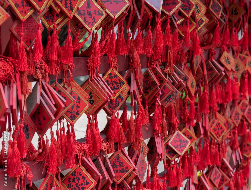Photo of Traditional Red Wishing Envelopes with Handwritten Wish. Greeting Card Red Plate Hanging on Wishing Tree